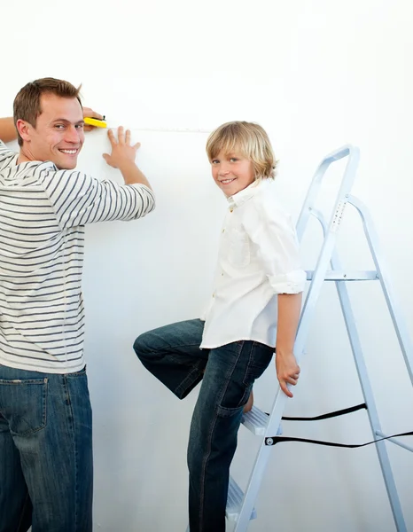 Sorridente padre e suo figlio decorare una stanza — Foto Stock