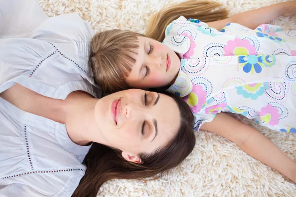 Mor och hennes dotter liggande på golvet — Stockfoto