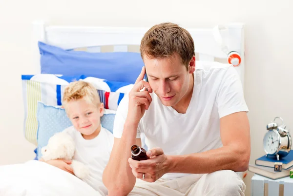 Homem atento cuidando de seu filho doente — Fotografia de Stock