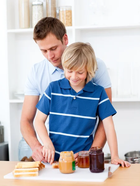 Liefdevolle vader zoon het ontbijt te bereiden helpen — Stockfoto