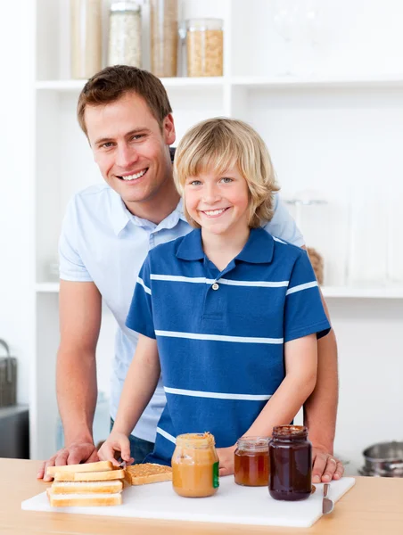 Uśmiechnięty ojciec pomoc syna przygotować śniadanie — Zdjęcie stockowe