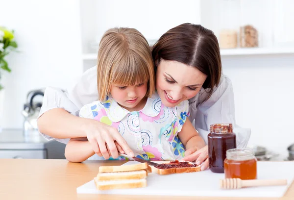 Brünette Mutter hilft ihrer Tochter das Frühstück zuzubereiten — Stockfoto