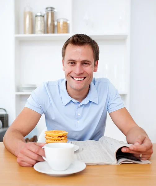 Yakışıklı adam kahvaltı sırasında gazete okuma — Stok fotoğraf