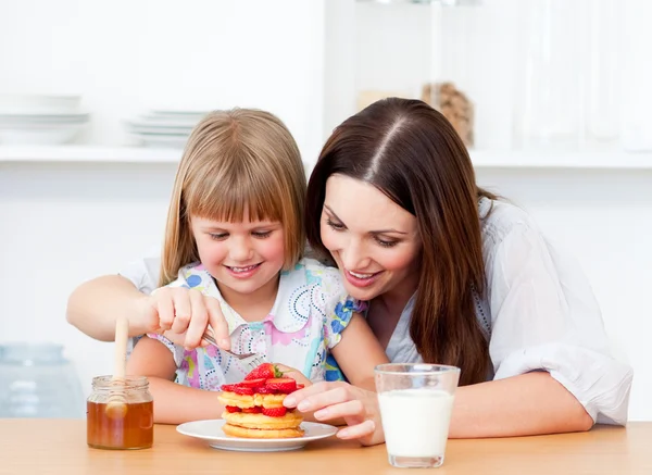 Fröhliches kleines Mädchen und ihre Mutter beim Frühstück — Stockfoto
