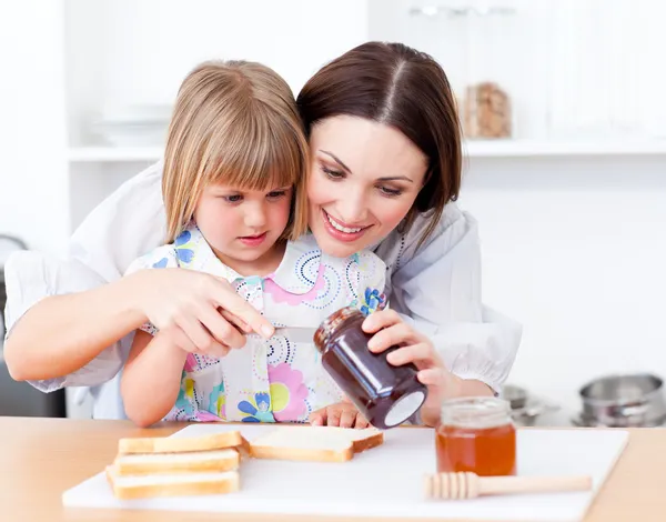 Entzückendes kleines Mädchen und ihre Mutter beim Zubereiten von Toasts — Stockfoto