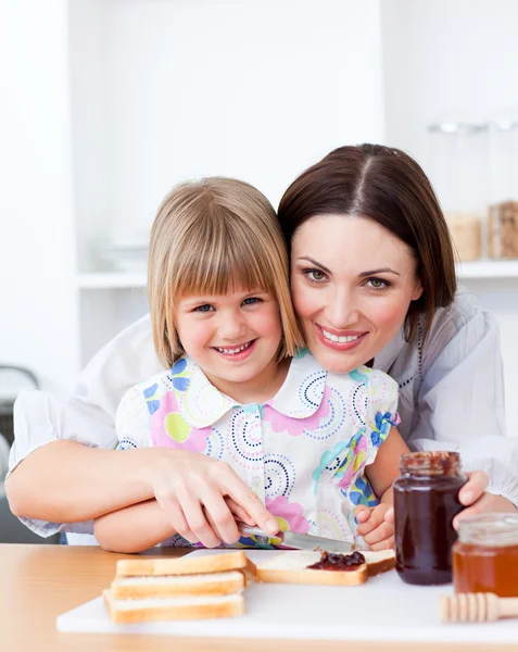 Sevimli küçük kız ve annesi tost hazırlanıyor — Stok fotoğraf