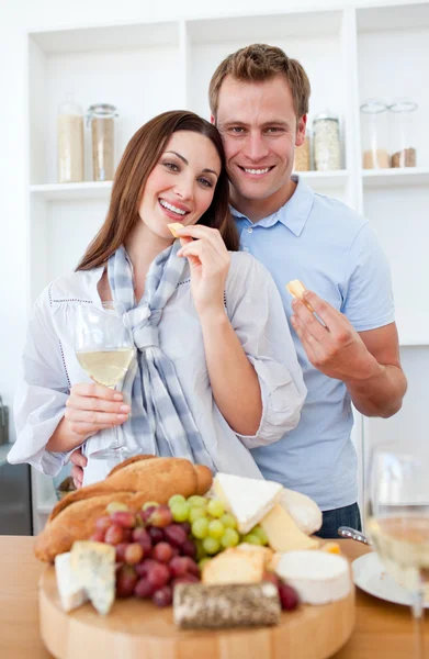 Cheerful couple drinking white wine and eating cheese — Stock Photo, Image