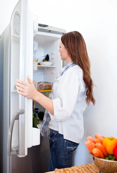 魅力的な女性は冷蔵庫の中に何かを探して — ストック写真