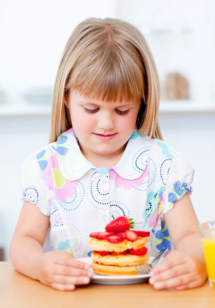 Bedårande liten flicka äter våfflor med jordgubbar — Stockfoto