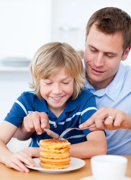 Attentive father and his son eating waffles — Stock Photo, Image