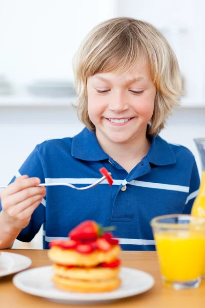 Bedårande pojke äta våfflor med jordgubbar — Stockfoto