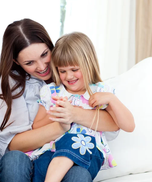 Cute girl sitting on her mother's lap celebrating a goal — Stock Photo, Image