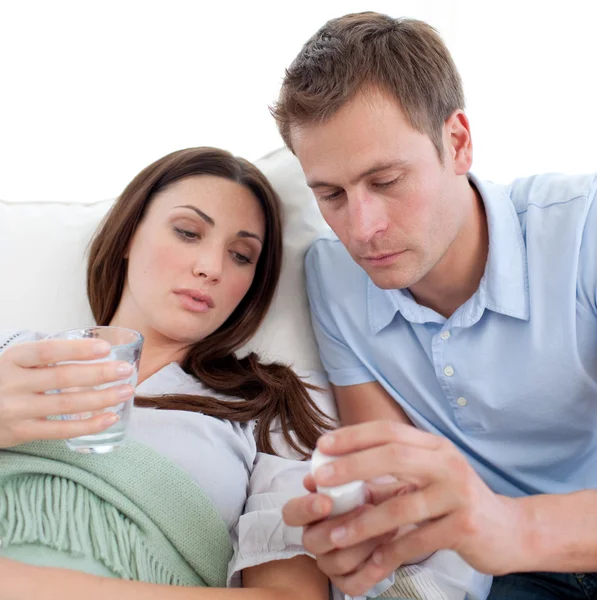 Mann gibt seiner Frau mit Grippe Tabletten — Stockfoto