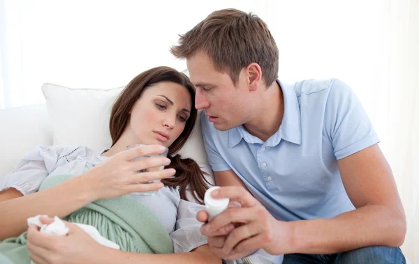 Marido carring sua esposa doente e dando a seus comprimidos — Fotografia de Stock