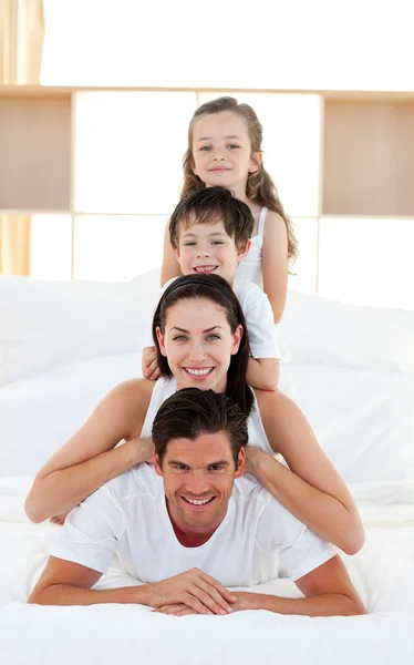 Семья веселится на родительской кровати — стоковое фото
