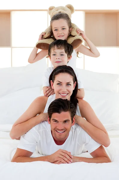 両親と子供一緒にベッドの上再生 — ストック写真