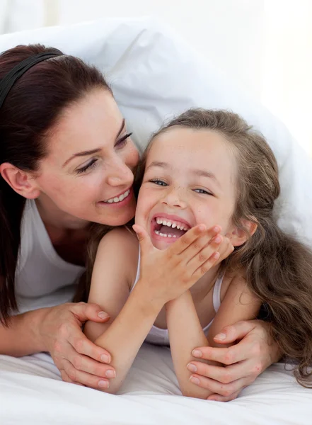 Küçük kız ve annesi yatağa eğleniyor — Stok fotoğraf