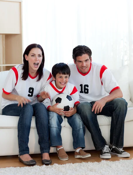 Родители и их сын смотрят футбольный матч — стоковое фото