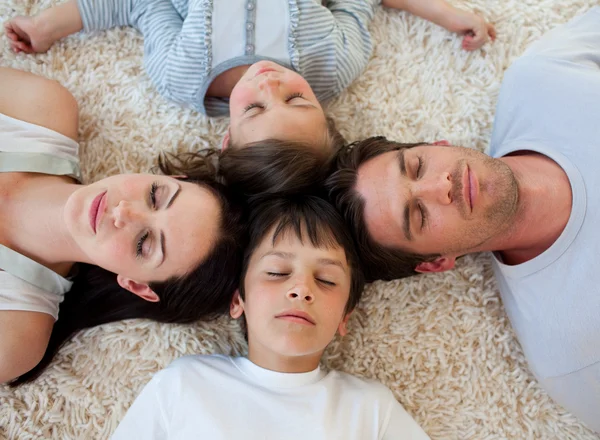 Família dormindo no chão com as cabeças juntas — Fotografia de Stock
