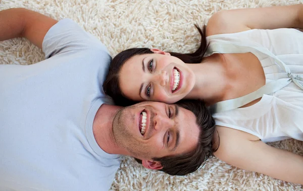 Sorridente coppia sdraiata sul pavimento — Foto Stock