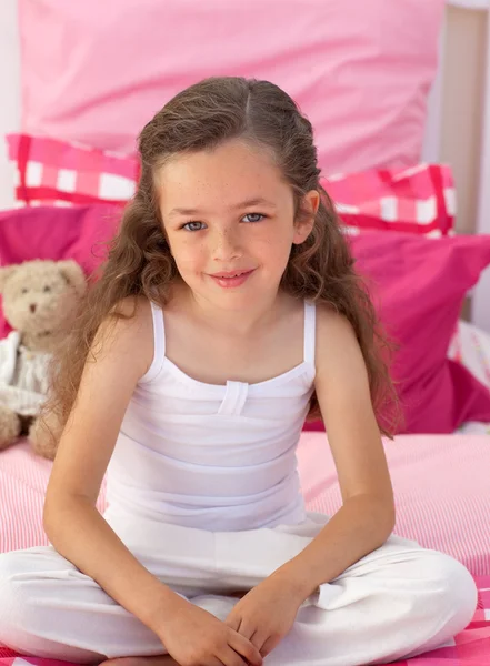 Dziewczynka siedzi na łóżku — Zdjęcie stockowe