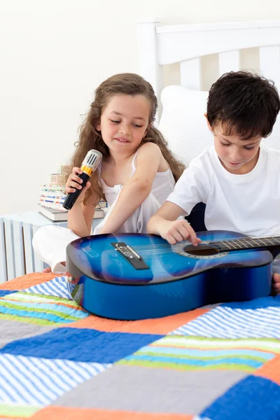 Irmão e irmã se divertindo com uma guitarra — Fotografia de Stock