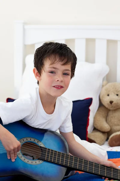 Портрет маленького хлопчика, який грає на гітарі — стокове фото