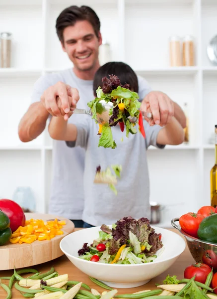 Heureux père et son fils préparant une salade — Photo