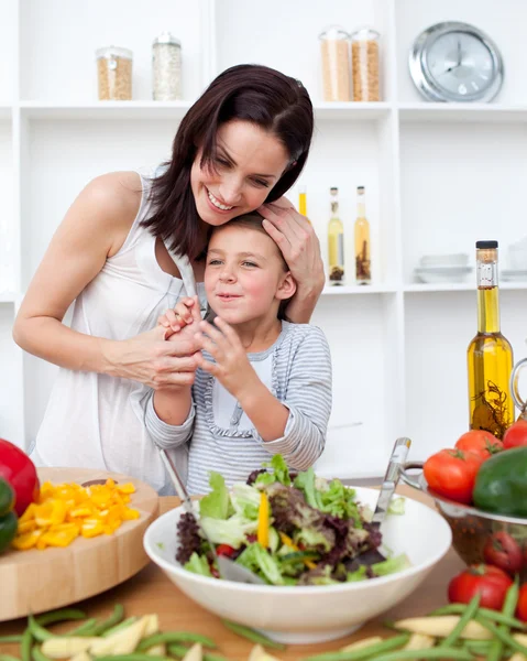 Litlle girl and her mother preparing a salad — Stock Photo, Image