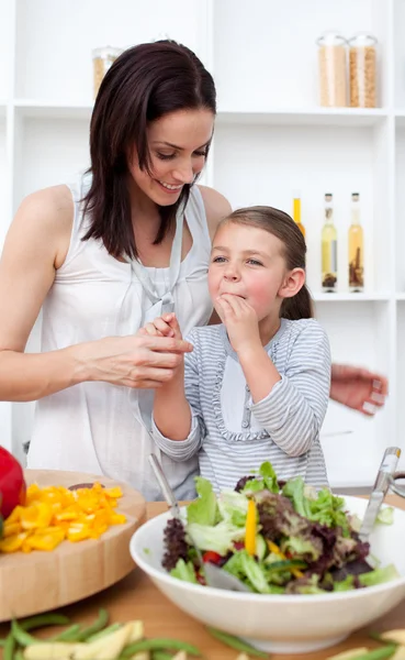 Kleines Mädchen probiert Salat mit ihrer Mutter — Stockfoto