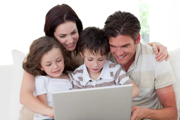 Family using a laptop on the sofa — Stock Photo, Image