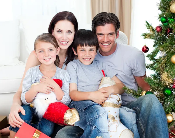 Porträtt av en leende familj i juletid som innehar massor av p — Stockfoto