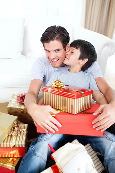 Zoon kussen van zijn vader na ontvangst van een gift van Kerstmis — Stockfoto