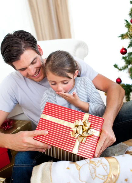 Surpreendido filhinha abrindo um presente de Natal com seu f — Fotografia de Stock