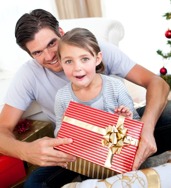 Noel hediyesi ile onun fathe açılış sürpriz küçük kız — Stok fotoğraf
