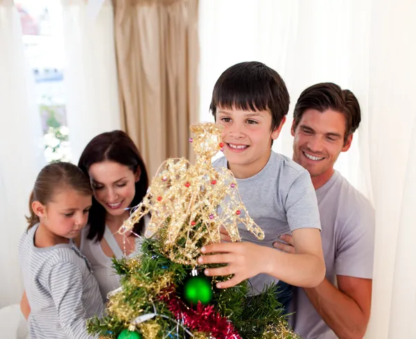 Família sorridente decorando uma árvore de Natal em casa — Fotografia de Stock