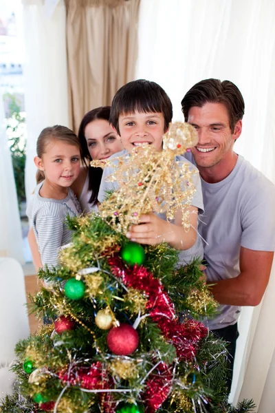 Ευτυχισμένη οικογένεια στολίζει ένα χριστουγεννιάτικο δέντρο — Φωτογραφία Αρχείου