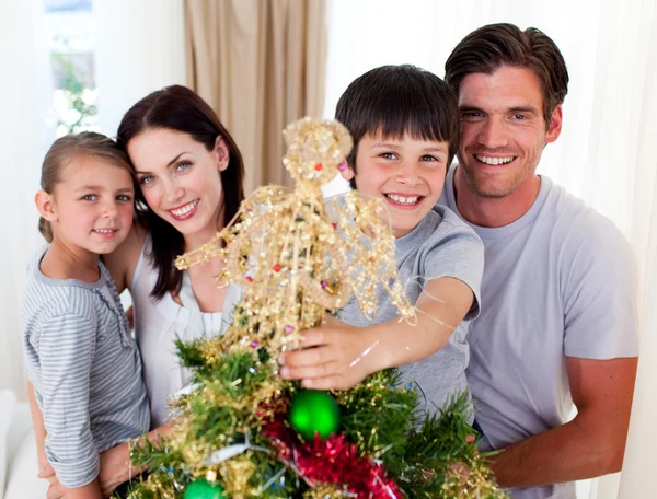 Porträt einer Familie, die einen Weihnachtsbaum schmückt — Stockfoto