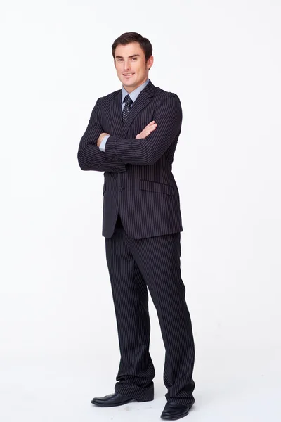 Confident businessman with folded arms against white — Stock Photo, Image