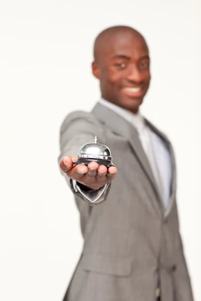 Hombre de negocios étnico sosteniendo una campana de hotel — Foto de Stock