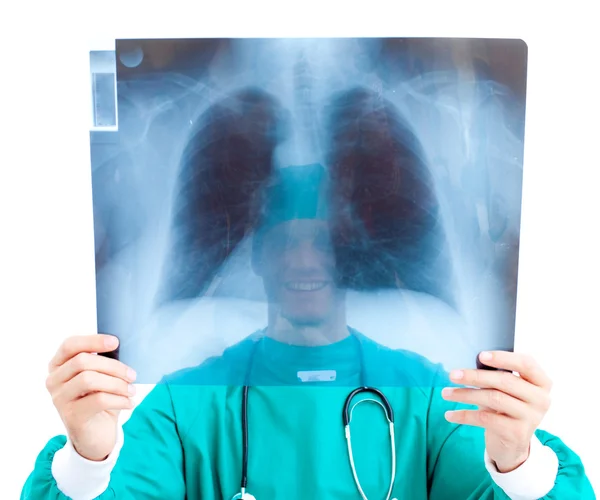 Улыбающийся хирург смотрит на рентген в своем кабинете — стоковое фото