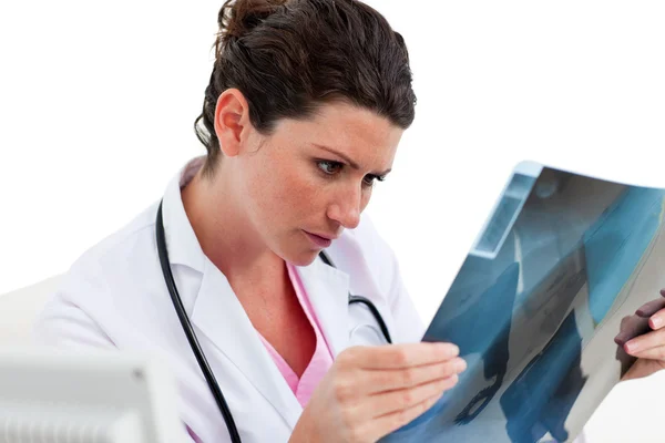 Poważne kobiece kobieta lekarz patrząc na RTG w gabinecie — Zdjęcie stockowe