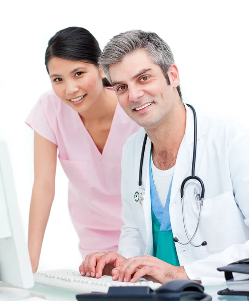 Usmívající se lékař a zdravotní sestra pracující na počítači — Stock fotografie