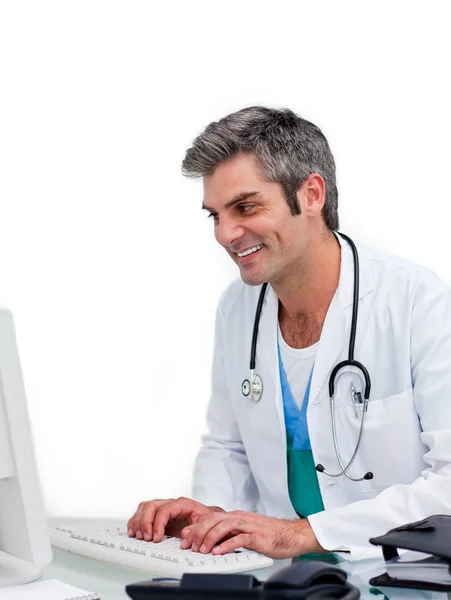 Médecin souriant travaillant sur un ordinateur — Photo