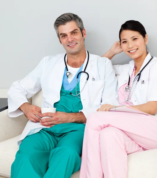 Médicos sonrientes relajándose y tomando café —  Fotos de Stock