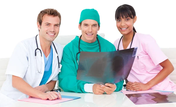 Squadra medica sorridente guardando i raggi X — Foto Stock