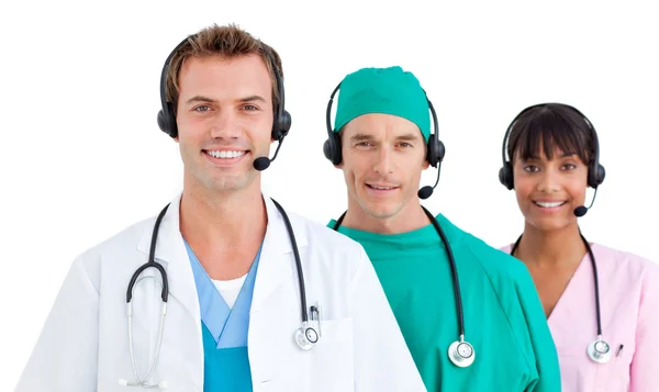 Usměvavá lékařský tým pomocí sluchátek s mikrofonem — Stock fotografie
