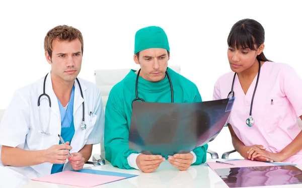 Серьезный медицинский персонал смотрит на рентген — стоковое фото