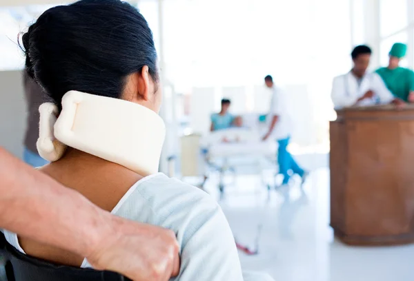 Brunette vrouw met een neckbrace zittend op rolstoel — Stockfoto