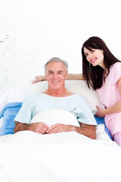 Enfermera cuidadora ajustando almohadas para un paciente mayor — Foto de Stock